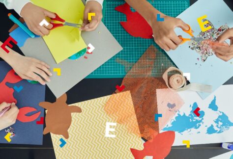 Dzieci wycinają kawałki kolorowego papieru i robią kolaże.