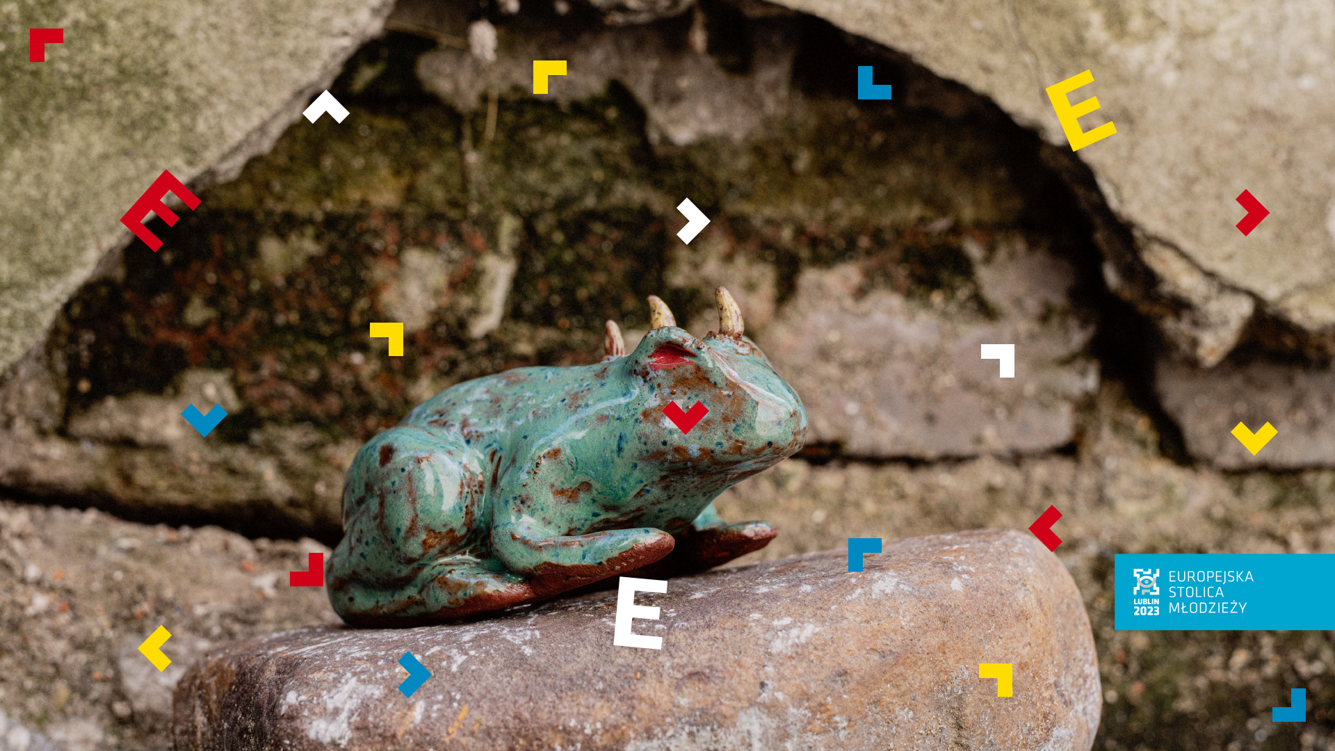 Figurka żaby umieszczona na kamieniu.