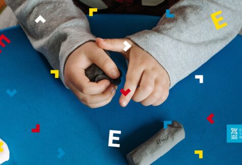 Ręce dziecka, które na stole ugniata plastelinę.