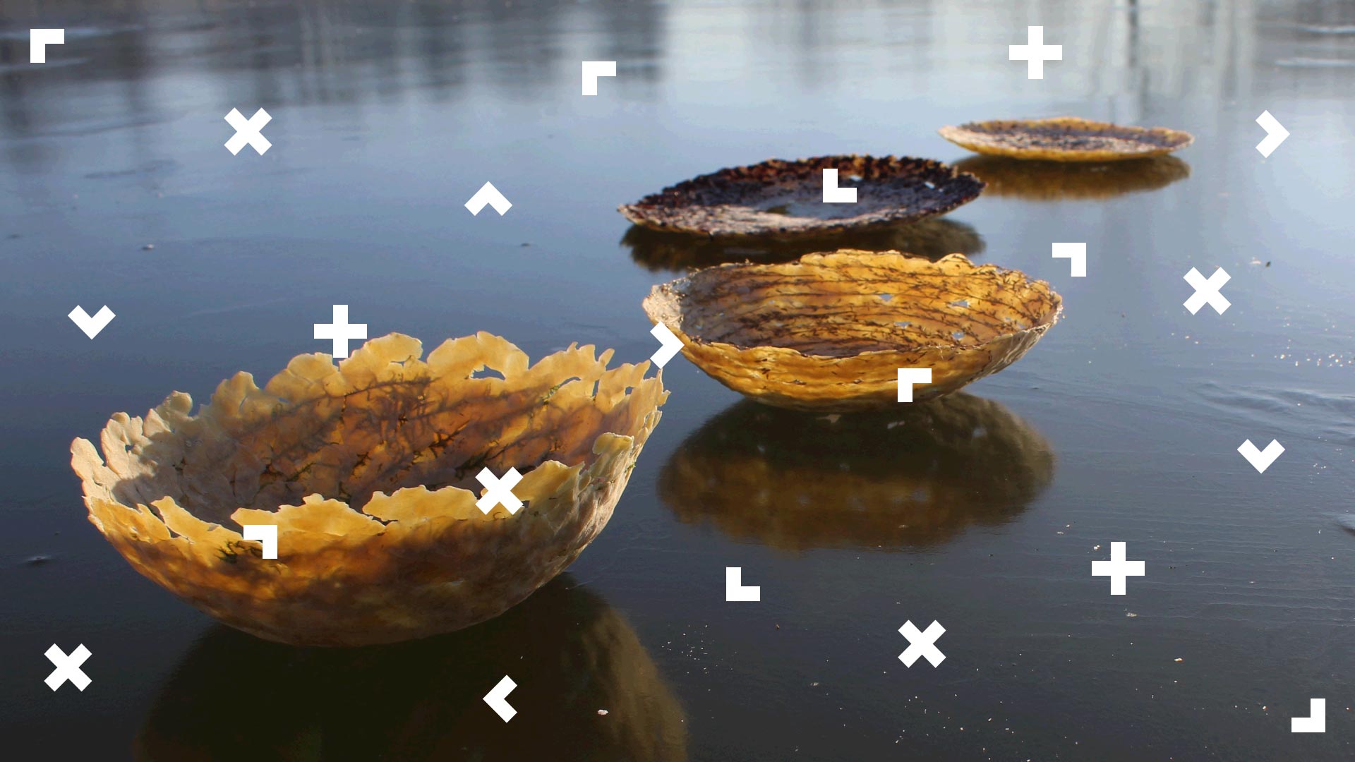 Na wodzie unoszą się cztery półokrągłe łódki przypominające głębokie talerze. Są wykonane z naturalnych elementów, prawdopodobnie jest to odlew z gliny.