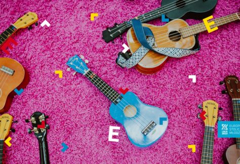 Na różowym dywanie leży dużo ukulele.