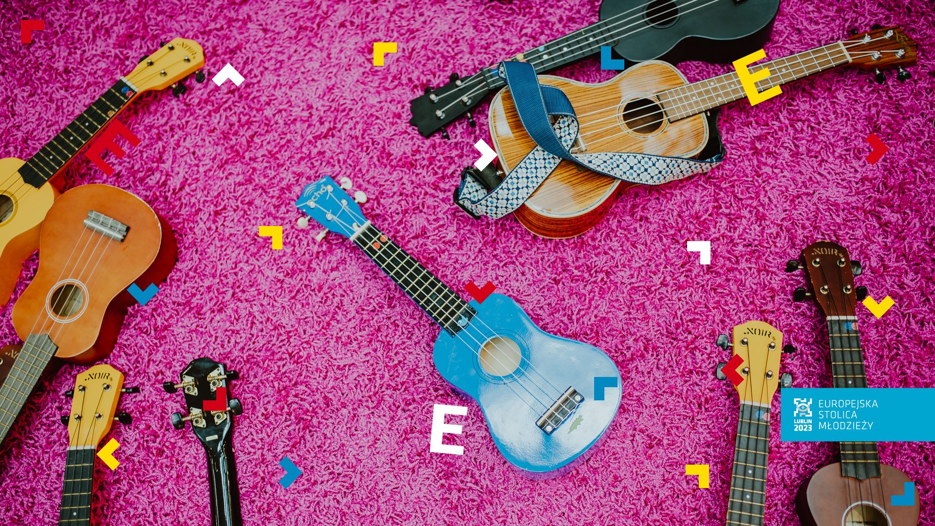 Na różowym dywanie leży dużo ukulele.