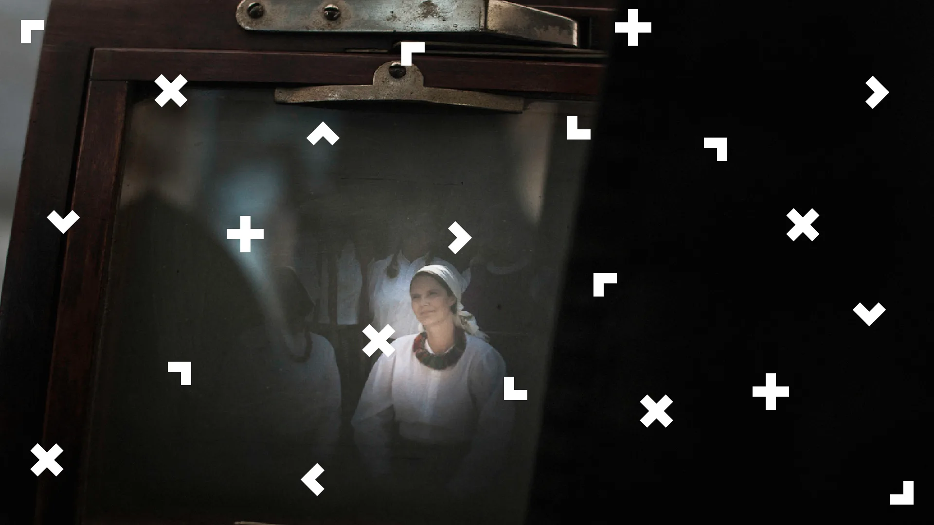 W drewnianej ramce fotografia z kobietą ubraną w strój ludowy.