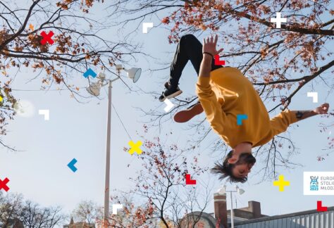 Chłopak robi salto między drzewami.