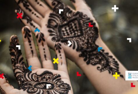 Dłonie młodej osoby z tatuażami zrobionymi czarną henną.