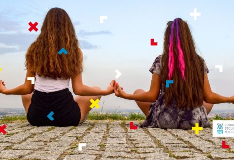 Dwie kobiety siedzą w pozycji do jogi.