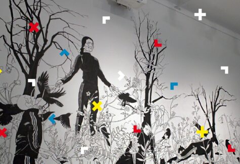 Obrazek na ścianie. Ludzie otoczeni są drzewami i ptakami.