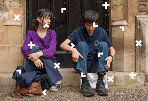 Chłopak i dziewczyna siedzą na schodach przed domem.