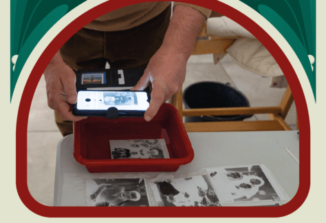 Negatyw fotograficzny moczy się w roztworze chemicznym. Mężczyzna robi mu zdjęcie. Napis: Sprawunki.