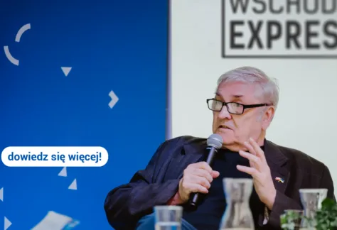 Starszy mężczyzna przemawia przez mikrofon.