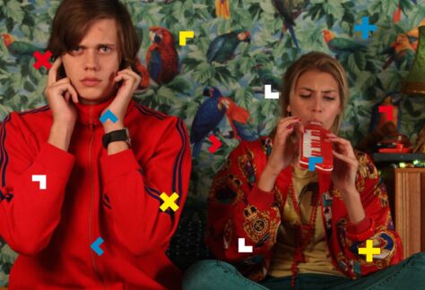 Kadr z filmu. Kobieta gra na harmonijce, a mężczyzna zasłania uszy.