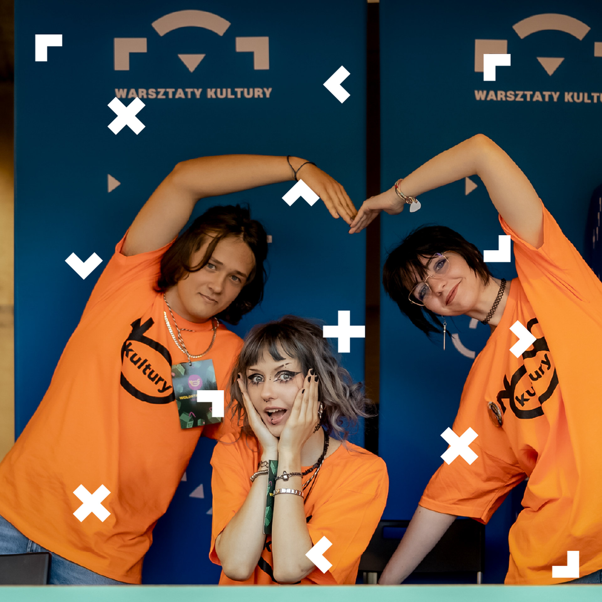 wolo_3_kwadrat Wolontariuszki Nocy Kultury robią serce rękami. Obsługują Punkt Informacyjny.