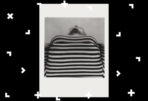 Kobieta leży na łóżku. Widać tylko jej koszulkę w paski.