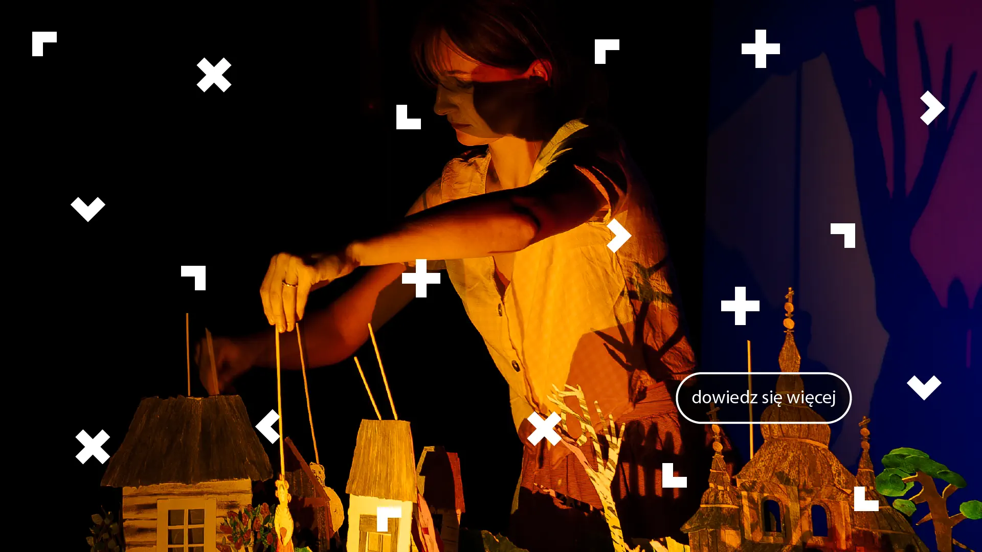 Kobieta porusza lalką na patyczku. Są tu domki i drzewa z kartonu. To zapowiedź spektaklu.