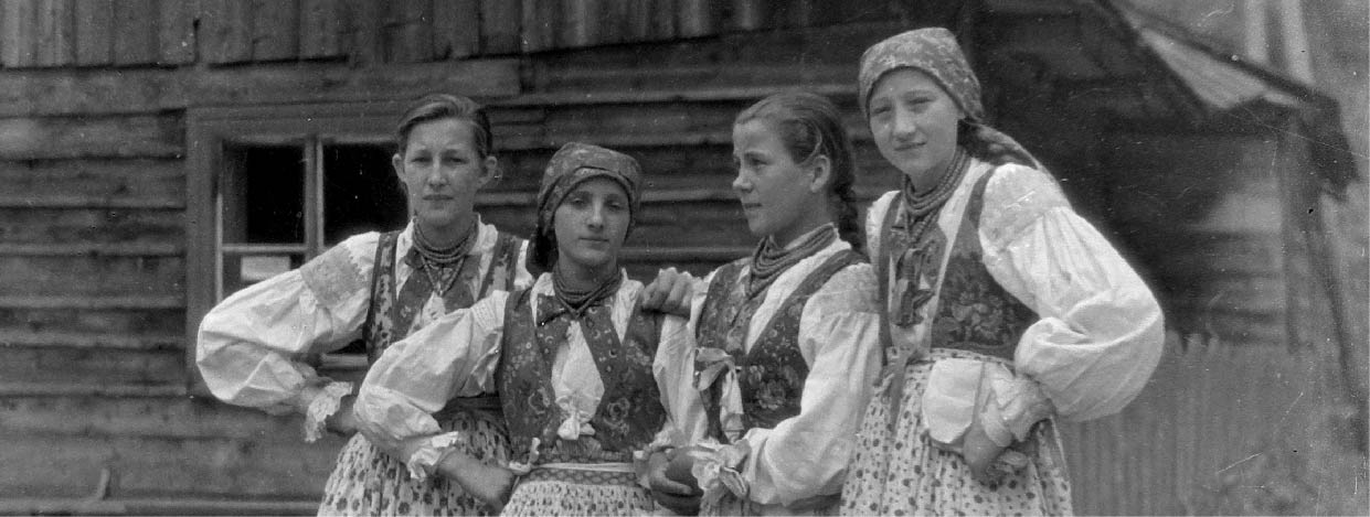 Czarno-biała fotografia kobiet w strojach ludowych.