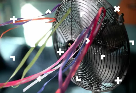 Grafika z kręcącym się wiatrakiem domowym. Są do niego przyczepione wstążki, które unoszą się do góry.