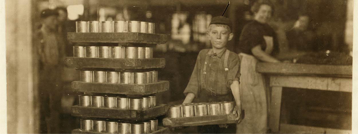 Czarno-biała fotografia chłopca w fabryce.