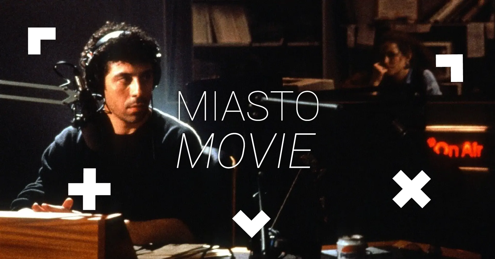 Mężczyzna siedzi przy biurku. To rozgłośnia radiowa. Napis Miasto Movie.