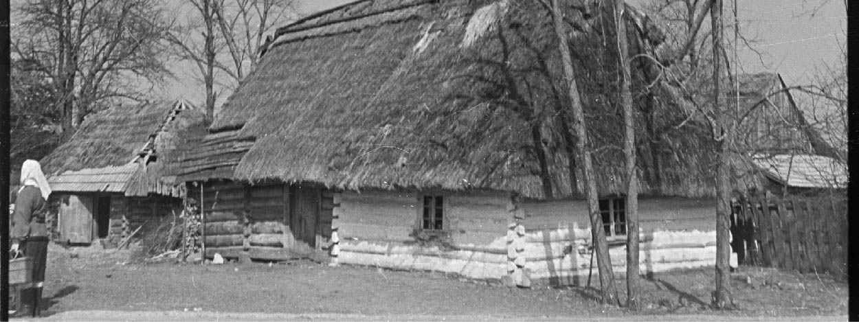 Czarno-biała fotografia drewnianej chaty.
