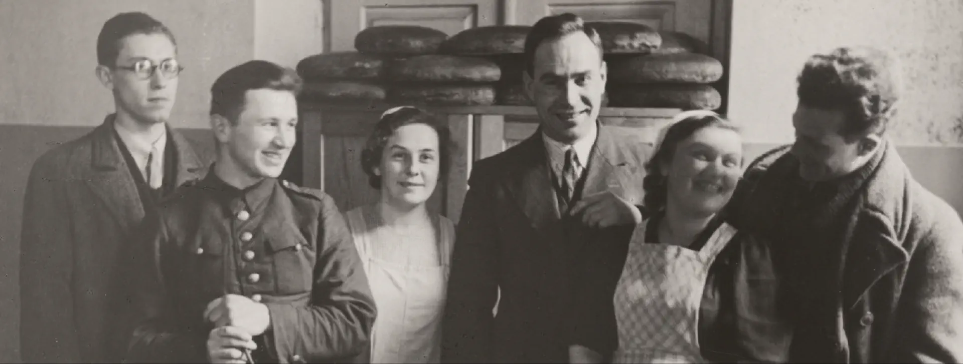 Czarno-biała fotografia przedstawiająca roześmianych panów i panie.