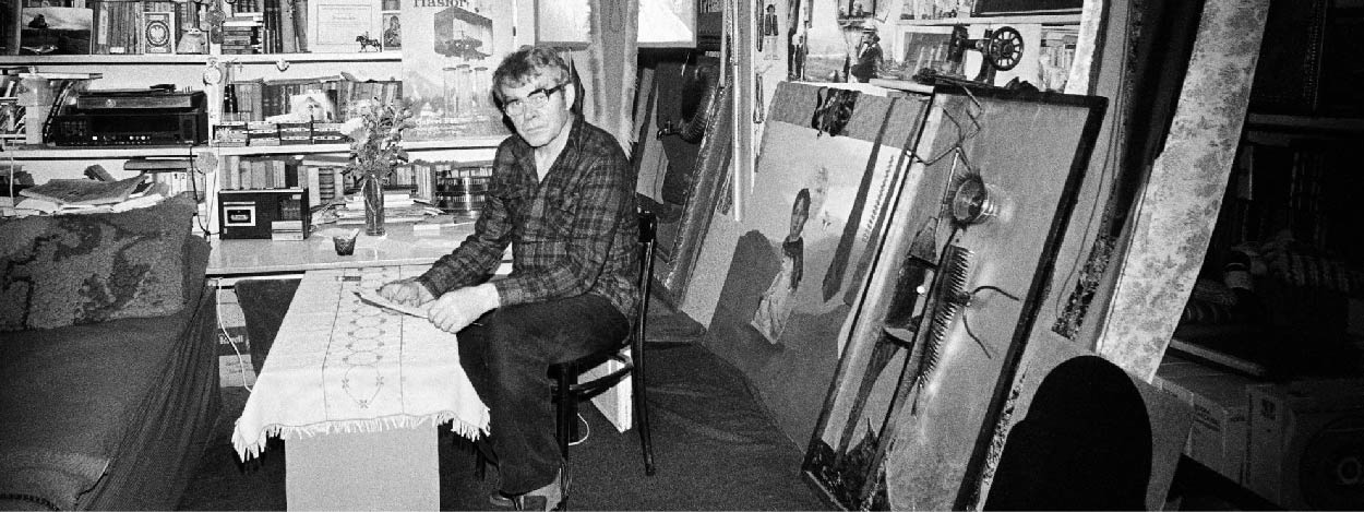 Czarno-białe zdjęcie mężczyzny, który siedzi przy stole.