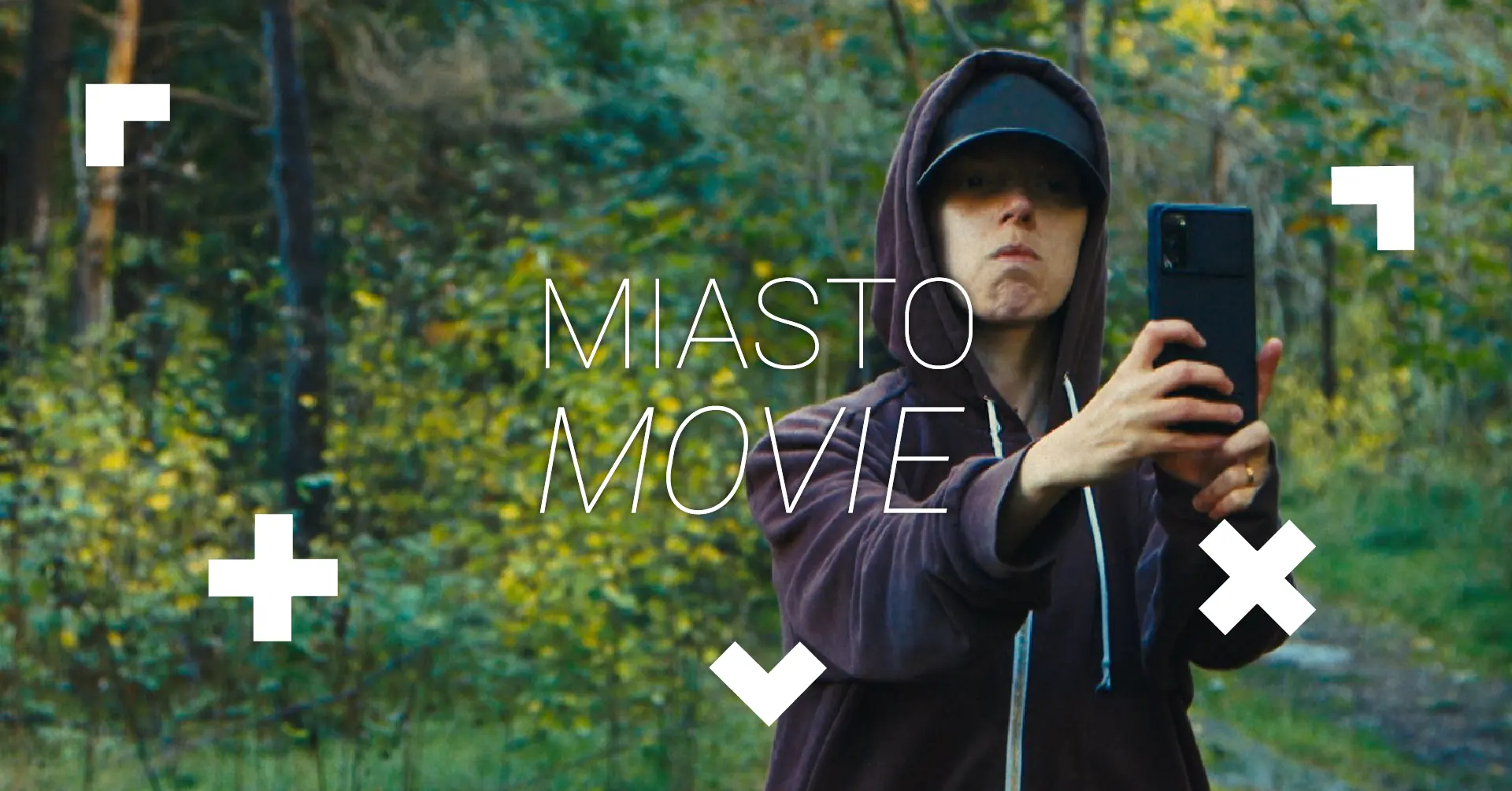 Nastolatek robi zdjęcie w lesie. Napis Miasto Movie.