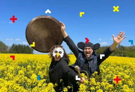 Kobieta i mężczyzna są przebrani za kury i biegają po łące.