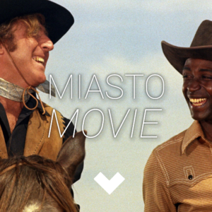 Dwaj kowboje śmieją się do siebie. Na środku logo Miasta movie.