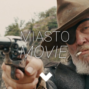 Mężczyzna z opaską na prawym oku i kapeluszem celuje broń przed siebie. Widać, że jest zły. Na środku logo Miasta movie.