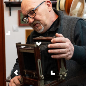 Starszy mężczyzna obsługuje aparat sprzed 100 lat.