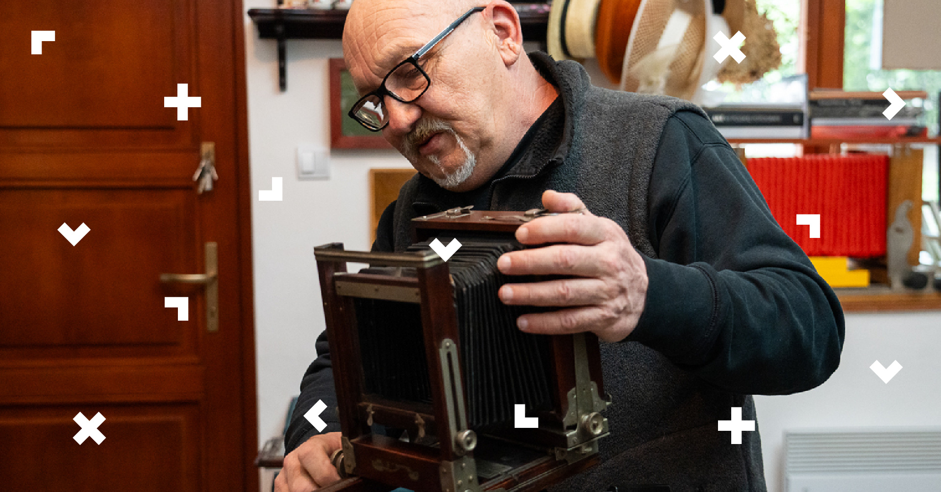 Starszy mężczyzna obsługuje aparat sprzed 100 lat.