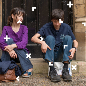 Dziewczyna i chłopak siedzą na schodku przed domem.