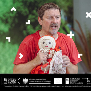 Mężczyzna trzyma lalkę i gra teatrzyk.