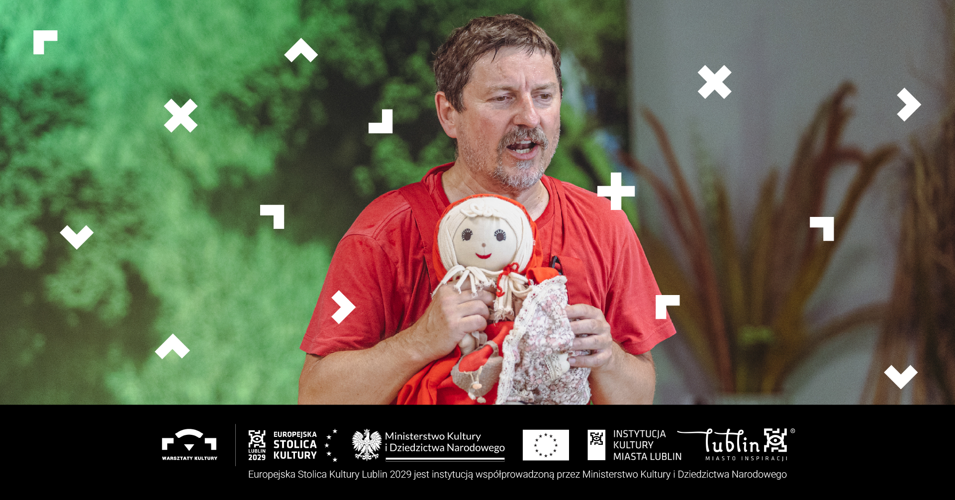 Mężczyzna trzyma lalkę i gra teatrzyk.