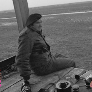 Zdjęcie starszego mężczyzny. Obok niego leżą aparaty fotograficzne.