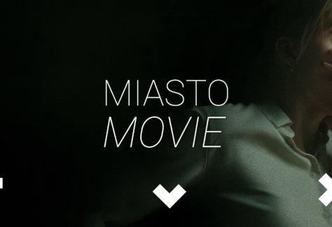 Kadr z filmu. Kobieta z przerażeniem zasłania usta. Napis: Miasto Movie.
